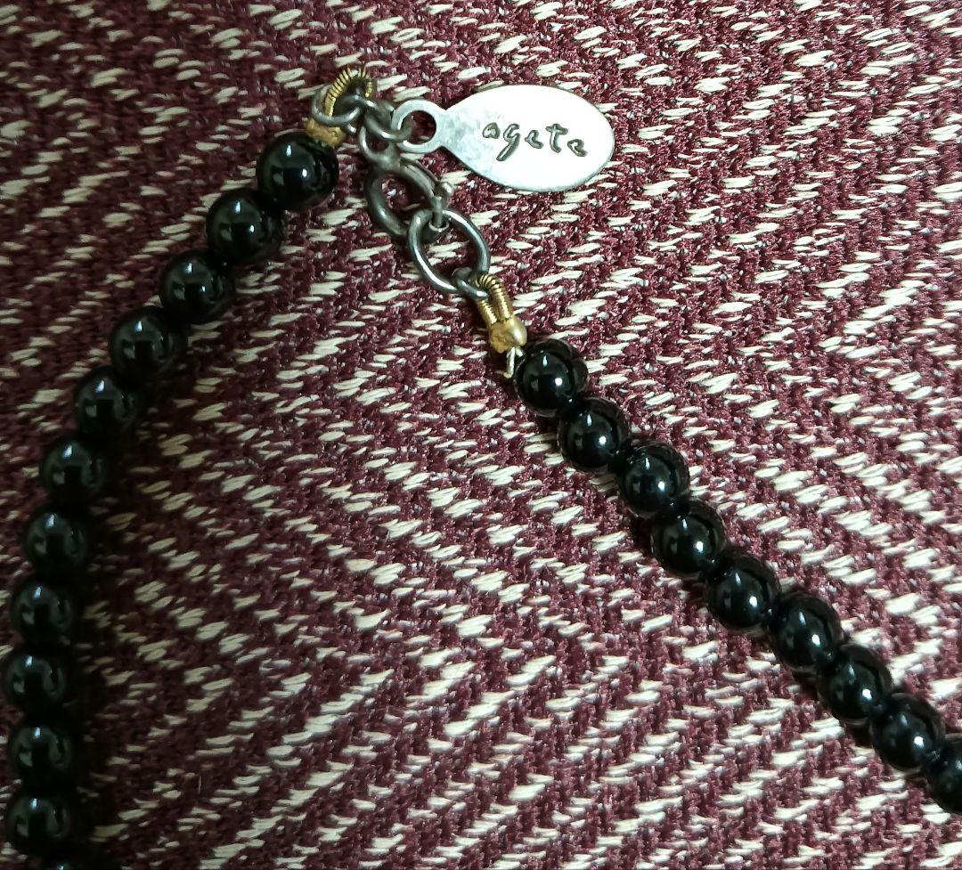 Agete Onyx Necklace with 4mm beads and a 9-10mm silver charm on a white background