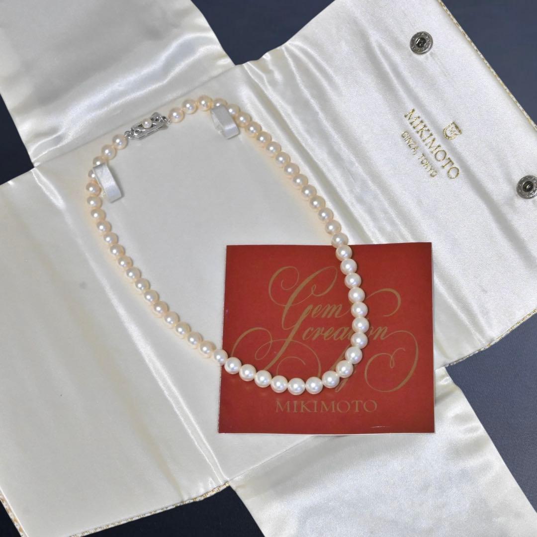 Highest-grade Mikimoto K14 Akoya pearl necklace with 7mm round pearls and white gold clasp on a white background