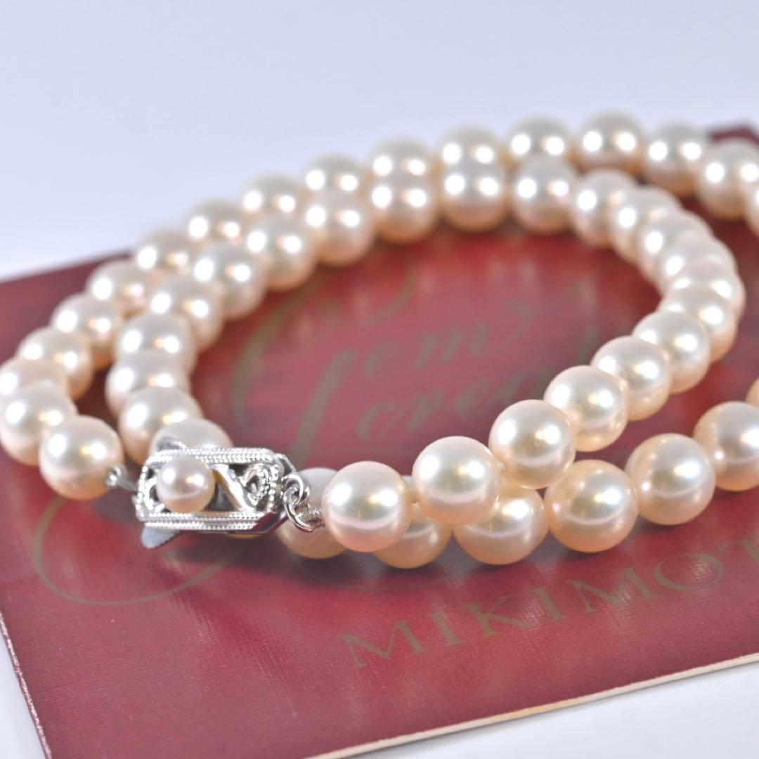 Highest-grade Mikimoto K14 Akoya pearl necklace with 7mm round pearls and white gold clasp on a white background