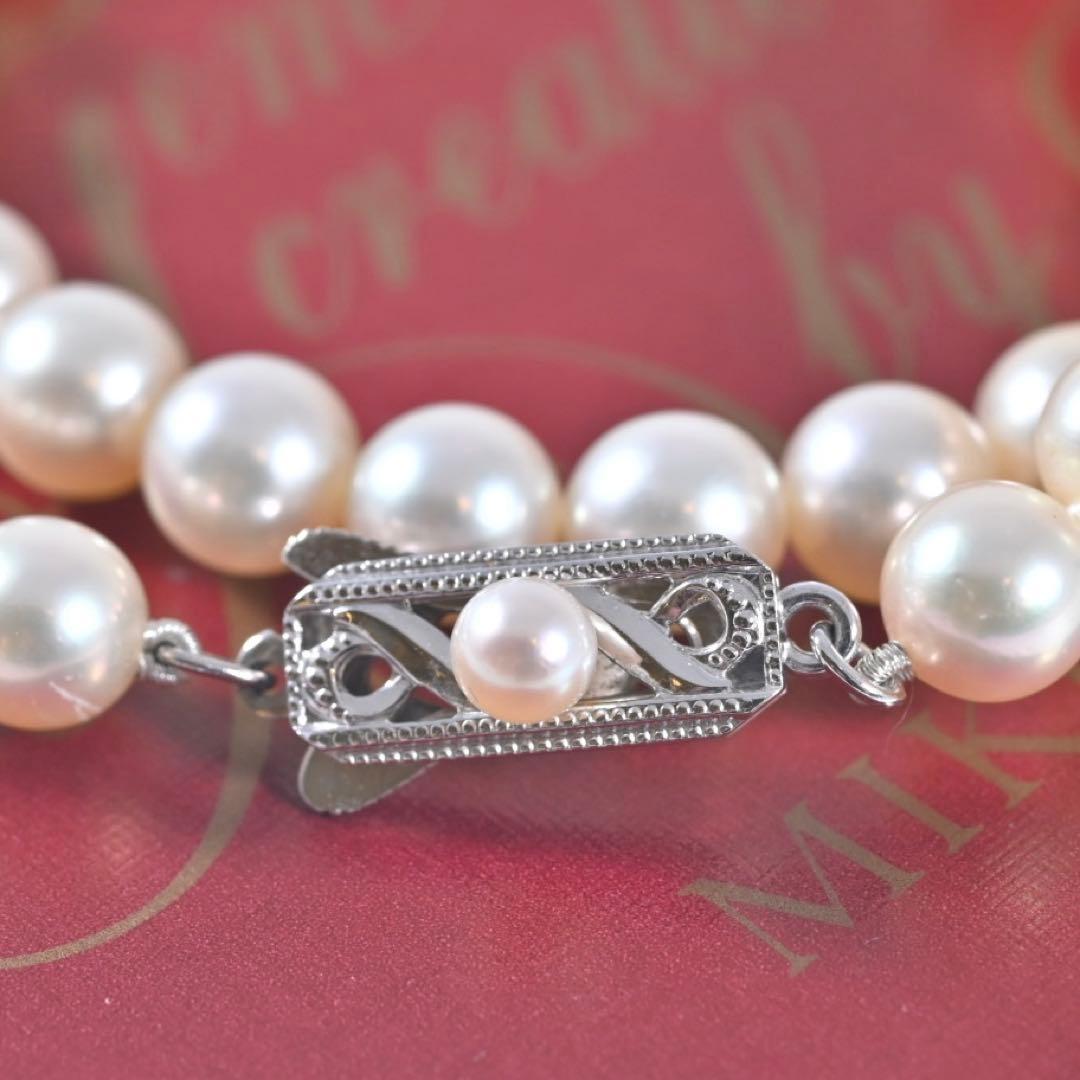 Highest-grade Mikimoto K14 Akoya pearl necklace with 7mm round pearls and white gold clasp on a white background