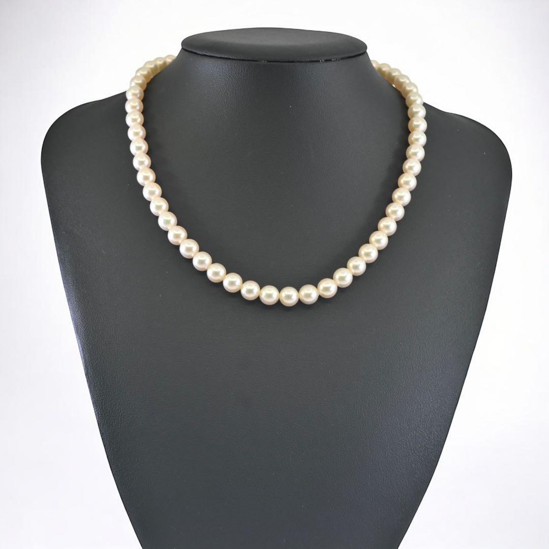 Highest-grade Mikimoto K14 Akoya pearl necklace with 7mm round pearls and white gold clasp on a white background