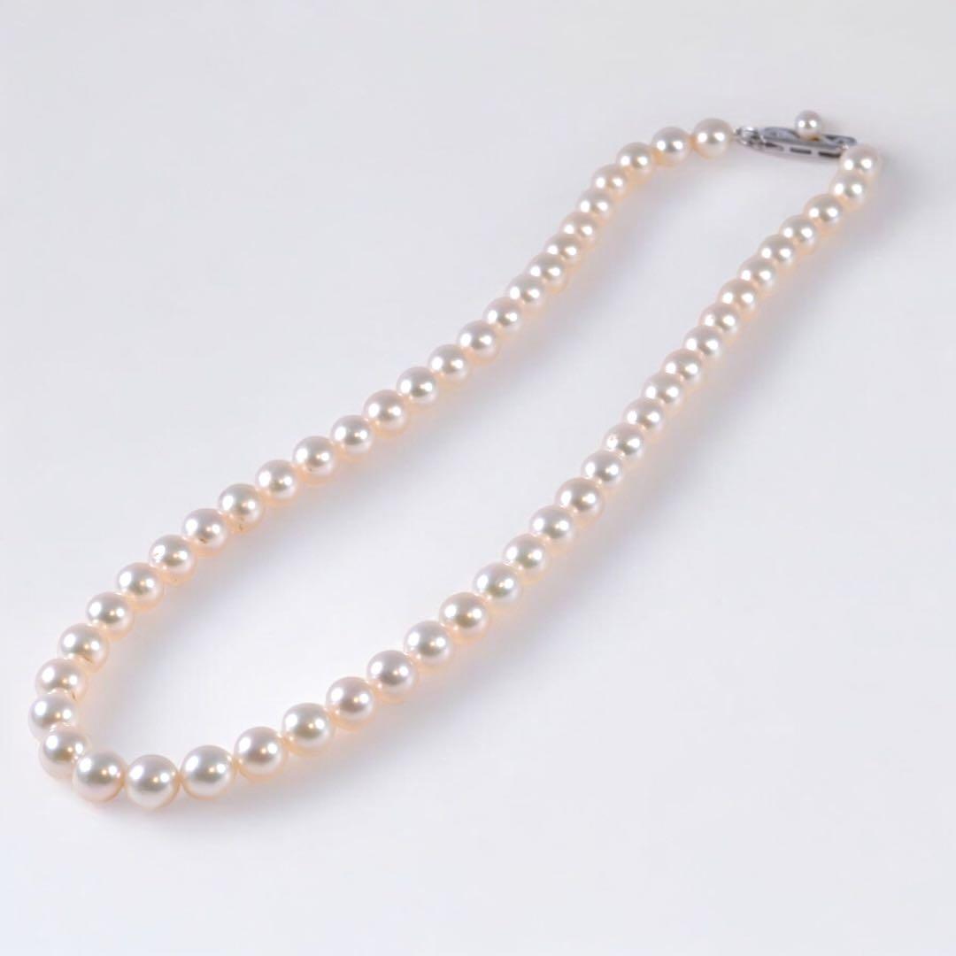 Highest-grade Mikimoto K14 Akoya pearl necklace with 7mm round pearls and white gold clasp on a white background