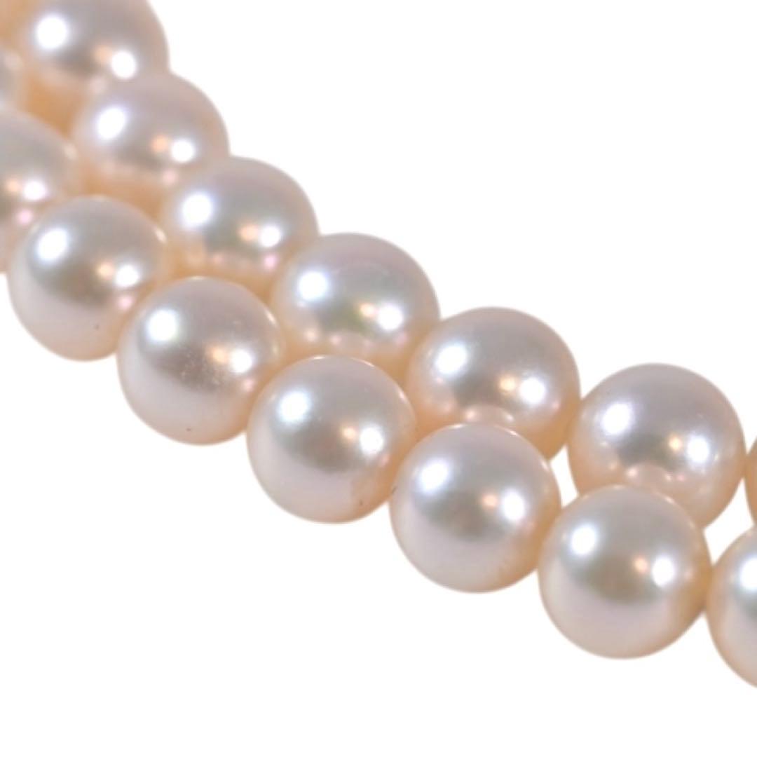 Highest-grade Mikimoto K14 Akoya pearl necklace with 7mm round pearls and white gold clasp on a white background