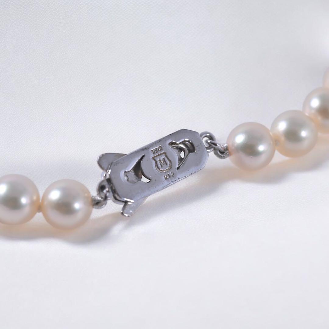 Highest-grade Mikimoto K14 Akoya pearl necklace with 7mm round pearls and white gold clasp on a white background