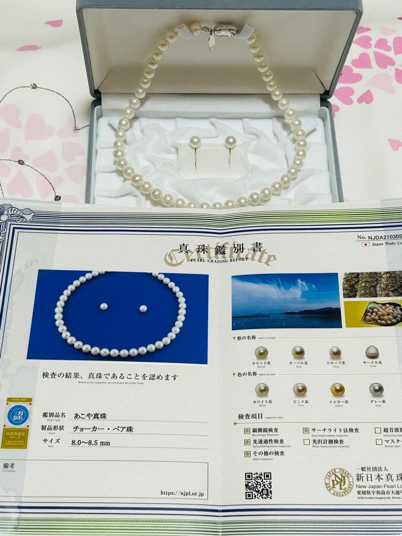Akoya pearl choker necklace with matching pair of pearl earrings on white background
