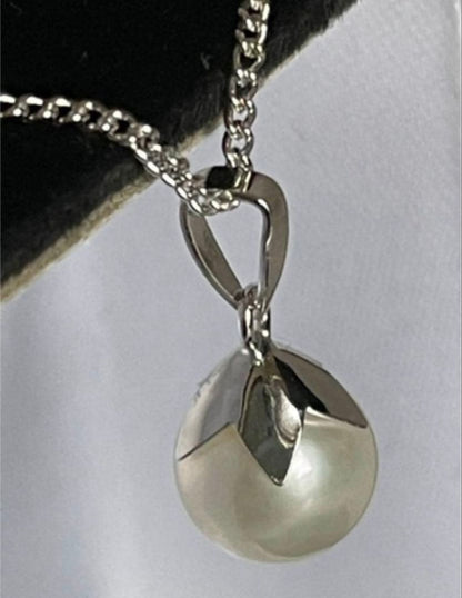 Close-up of 7mm Akoya pearl necklace pendant in 14K white gold on white background