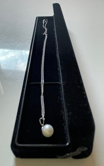 Close-up of 7mm Akoya pearl necklace pendant in 14K white gold on white background