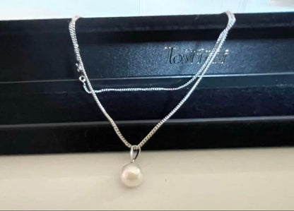 Close-up of 7mm Akoya pearl necklace pendant in 14K white gold on white background