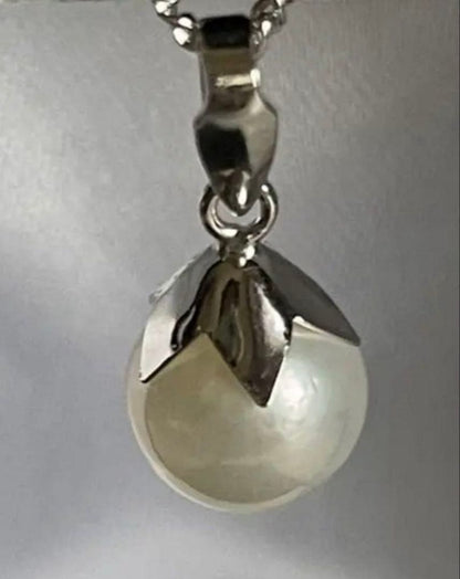 Close-up of 7mm Akoya pearl necklace pendant in 14K white gold on white background