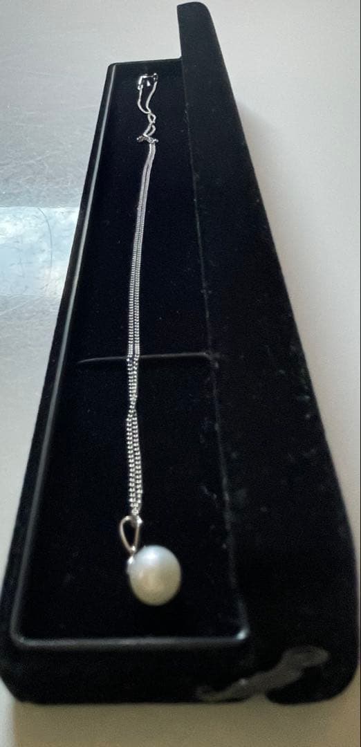 Close-up of 7mm Akoya pearl necklace pendant in 14K white gold on white background