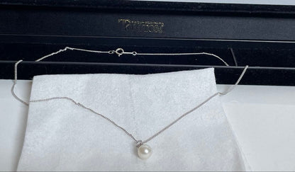 Close-up of 7mm Akoya pearl necklace pendant in 14K white gold on white background