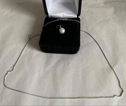 Close-up of 7mm Akoya pearl necklace pendant in 14K white gold on white background
