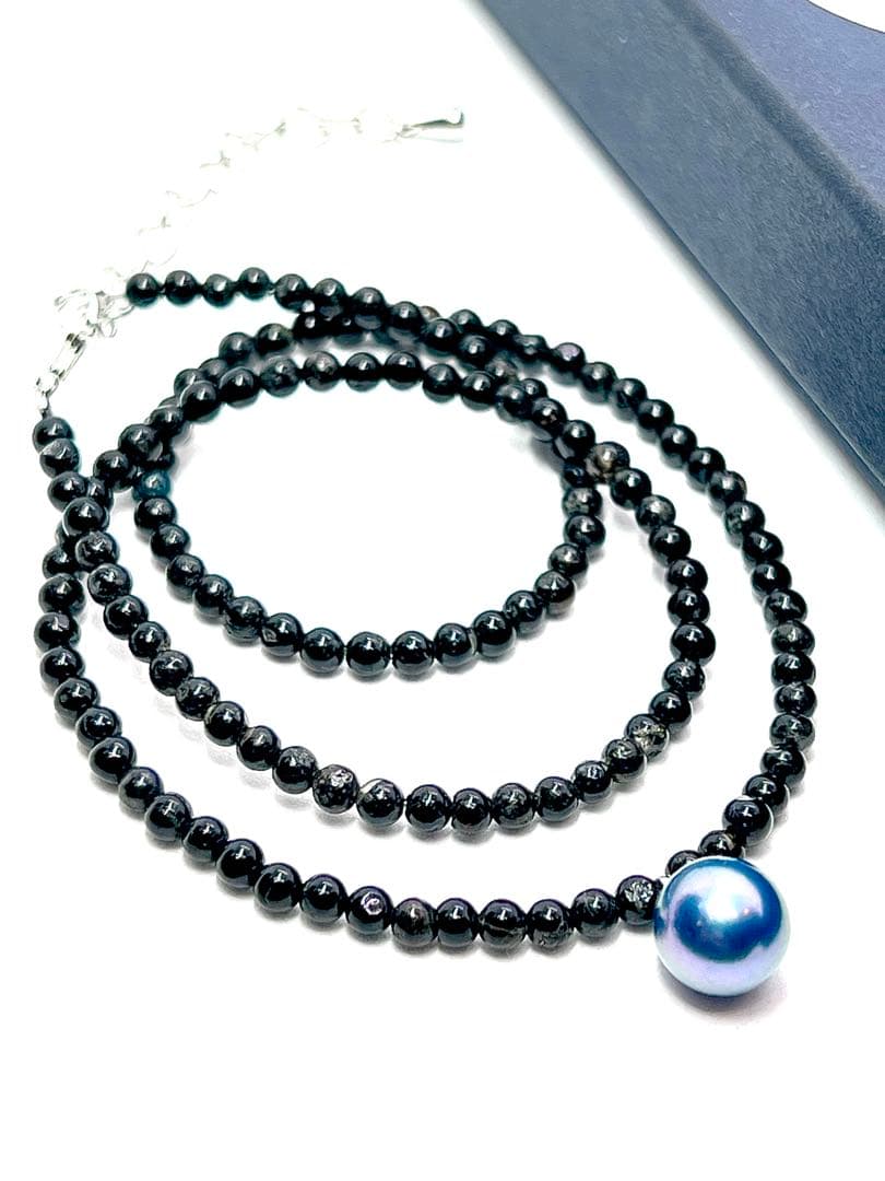 Oomamemono Akoya pearl black tourmaline necklace with round indigo blue pearls on white background