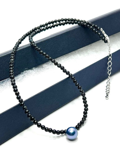 Oomamemono Akoya pearl black tourmaline necklace with round indigo blue pearls on white background