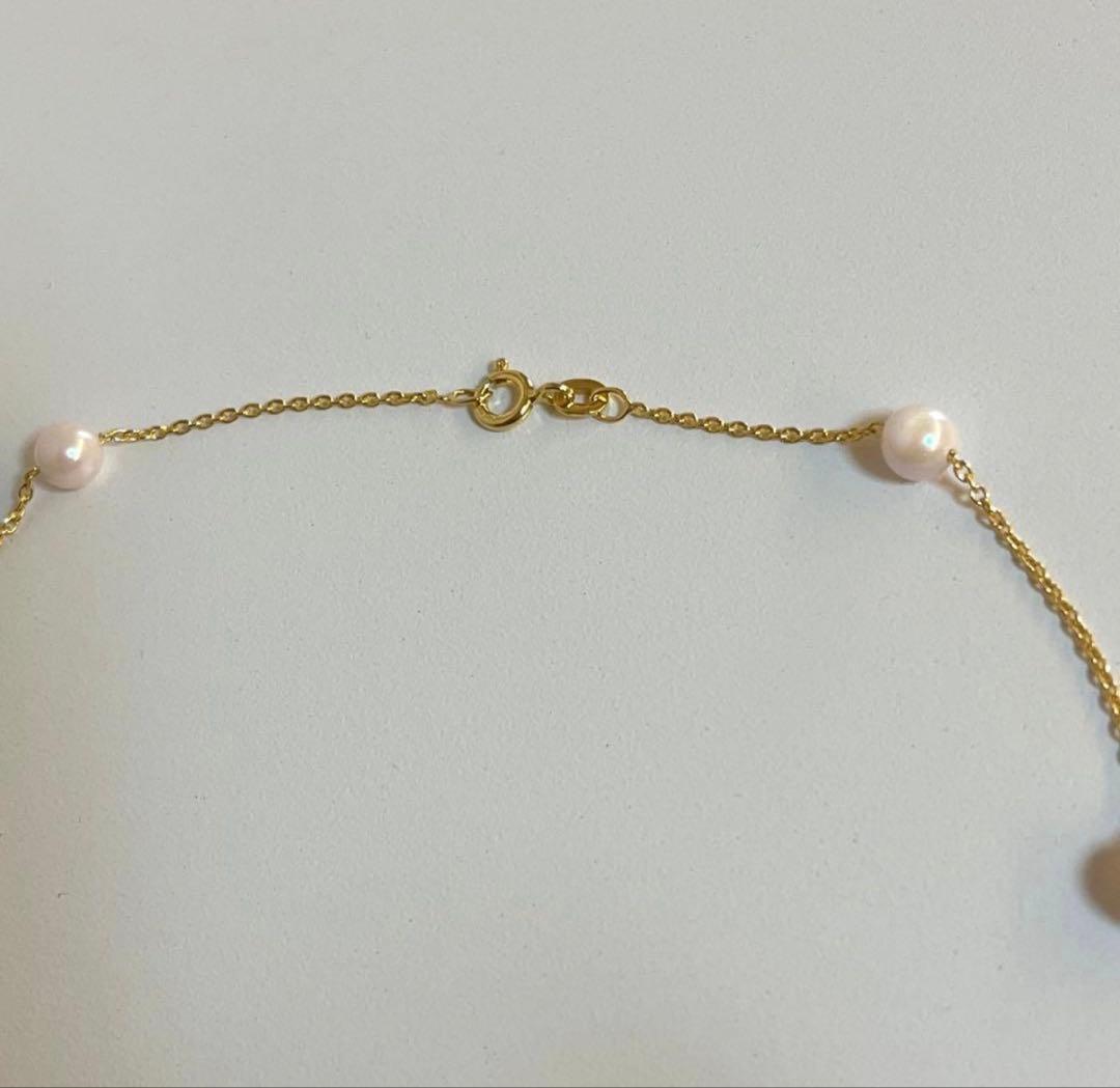 Akoya pearl station necklace with 9 white pink pearls and matching silver hook earrings set on white background