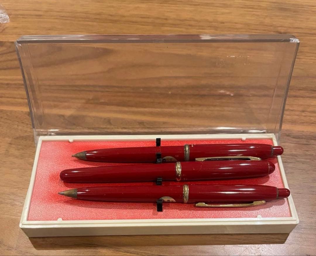 Pilot ballpoint pen mechanical pencil and fountain pen set in red and gold cracked case, showing wear and rust