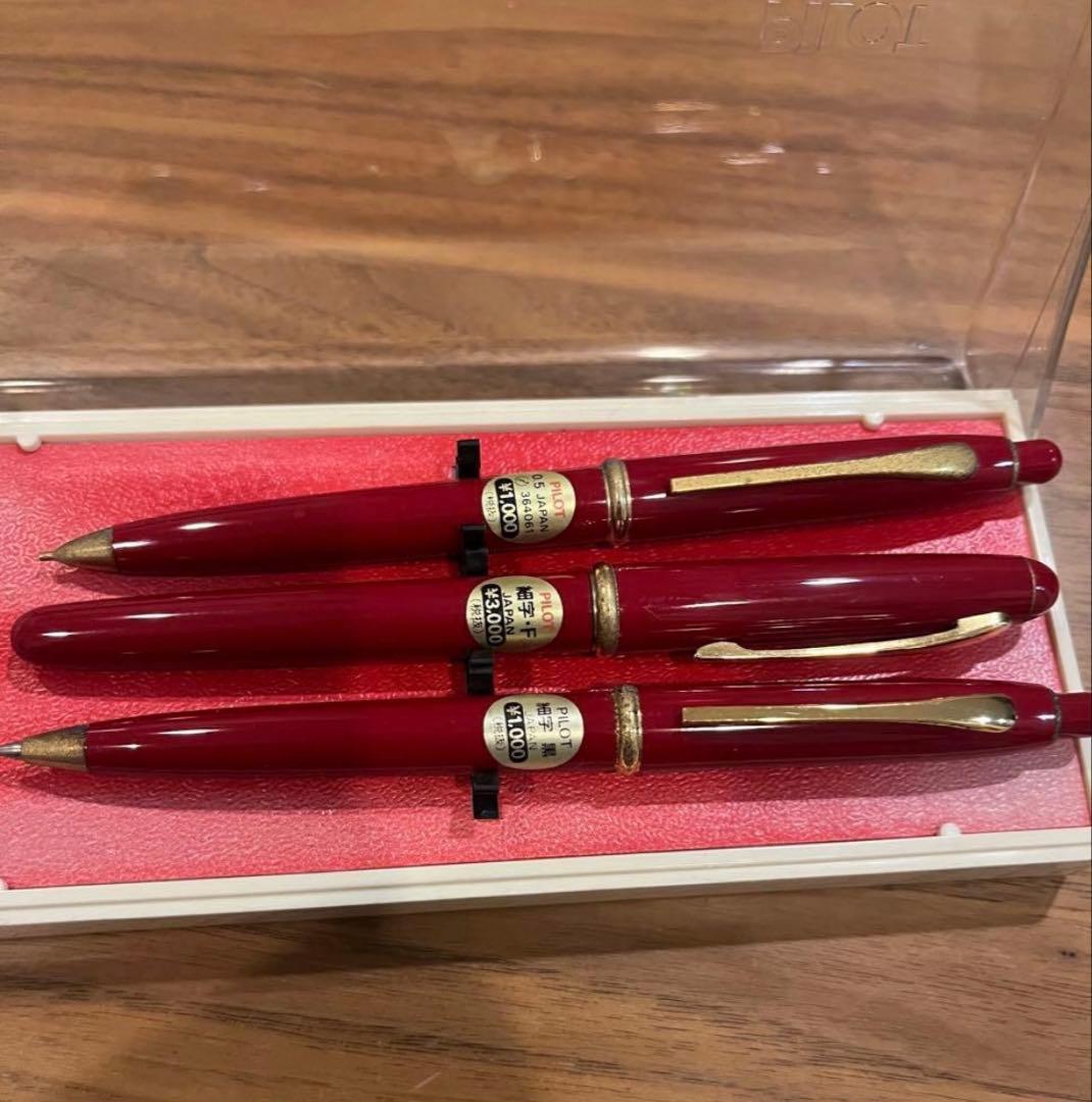 Pilot ballpoint pen mechanical pencil and fountain pen set in red and gold cracked case, showing wear and rust