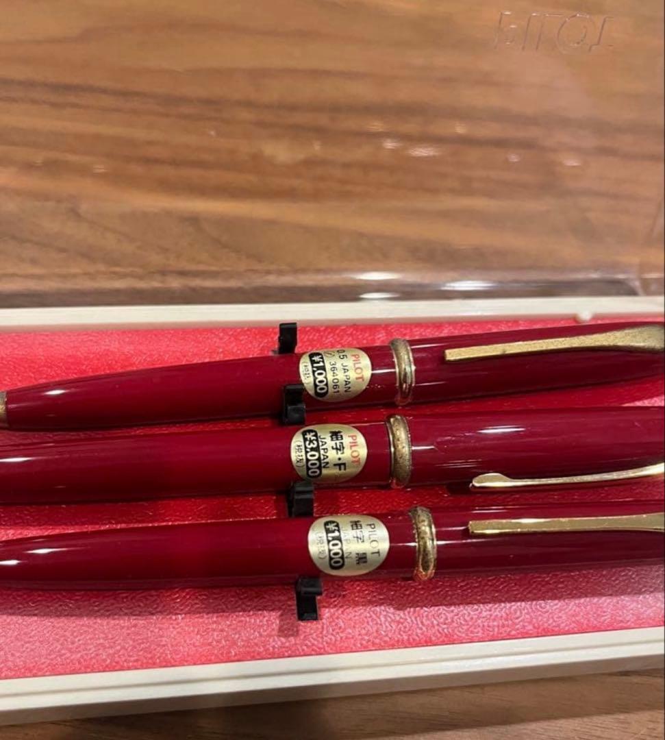 Pilot ballpoint pen mechanical pencil and fountain pen set in red and gold cracked case, showing wear and rust