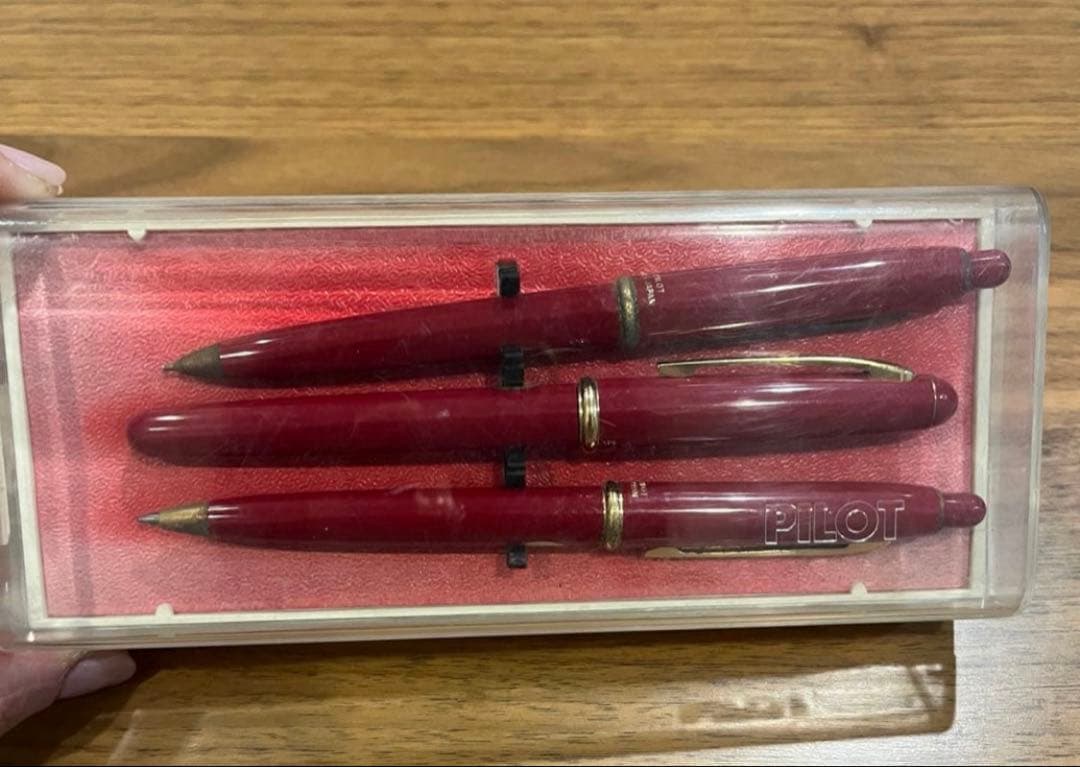 Pilot ballpoint pen mechanical pencil and fountain pen set in red and gold cracked case, showing wear and rust