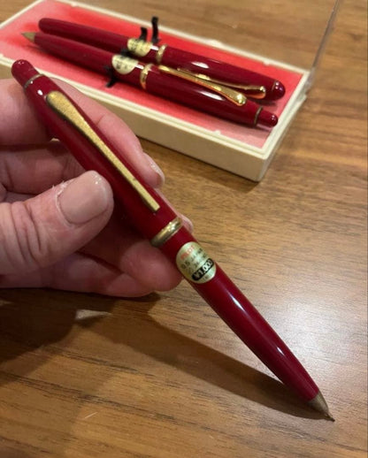 Pilot ballpoint pen mechanical pencil and fountain pen set in red and gold cracked case, showing wear and rust