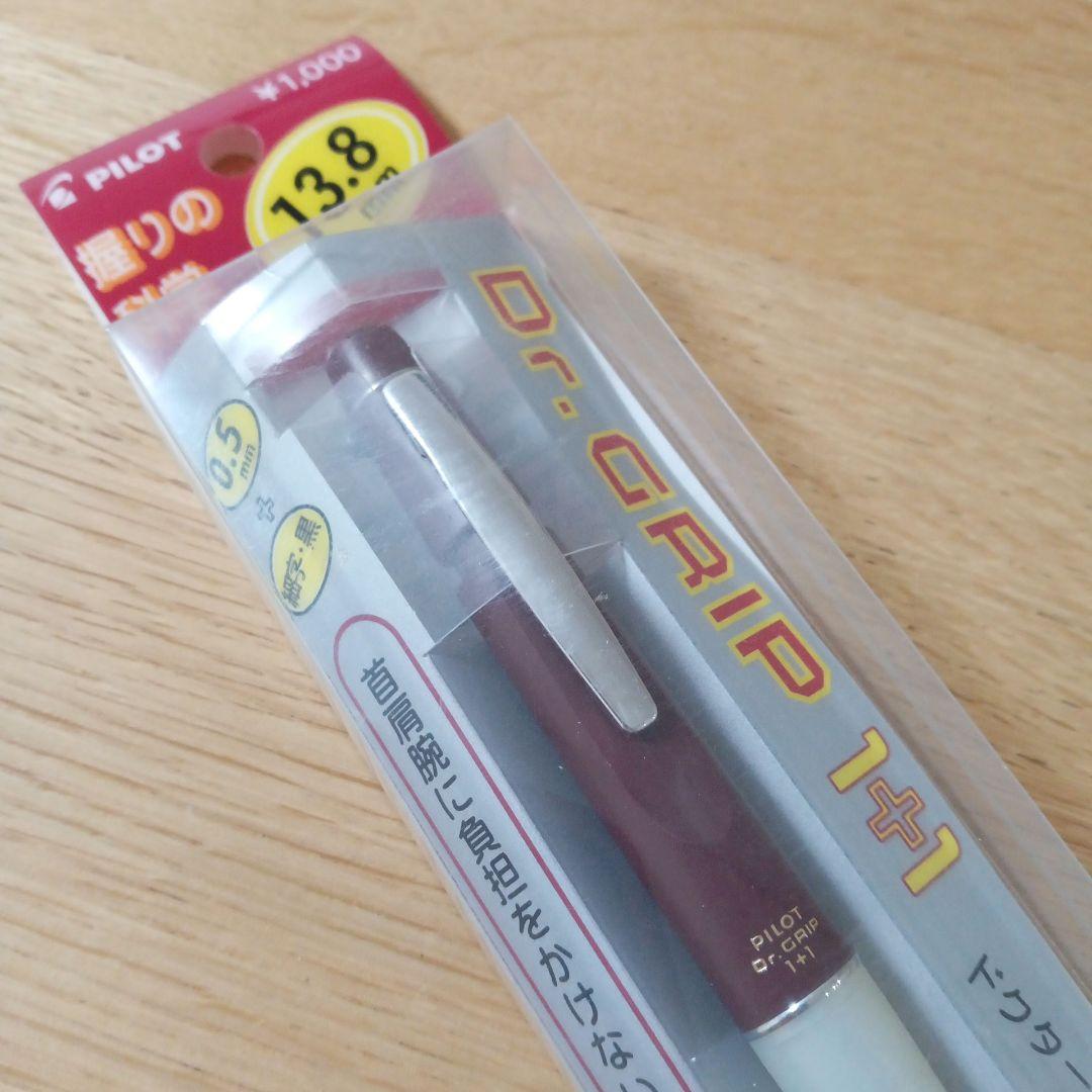 Pilot Dr. Grip 1+1 multi-function pen with dark red barrel, black 0.5mm ballpoint tip, and 0.5mm mechanical pencil
