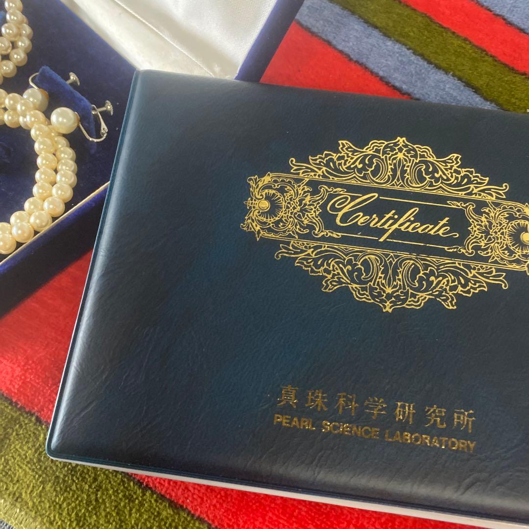 Akoya pearl necklace, matching earrings, and bracelet displayed on a white background