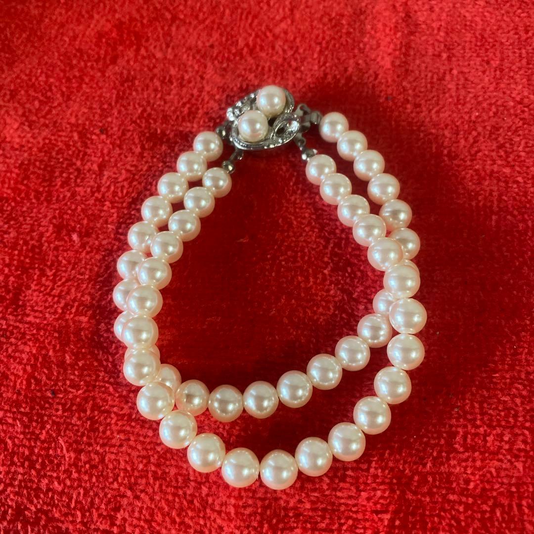 Akoya pearl necklace, matching earrings, and bracelet displayed on a white background