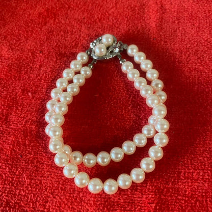 Akoya pearl necklace, matching earrings, and bracelet displayed on a white background