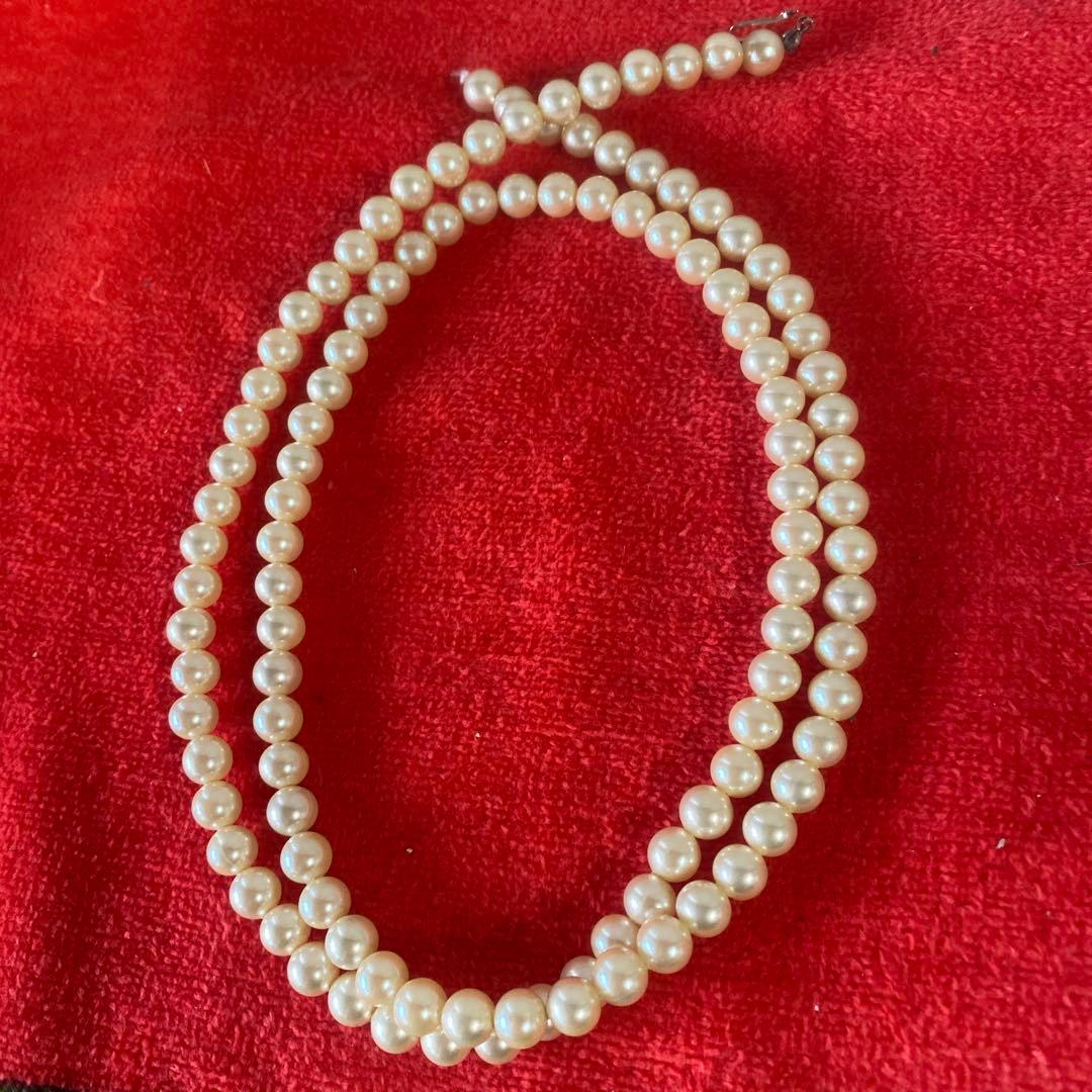 Akoya pearl necklace, matching earrings, and bracelet displayed on a white background