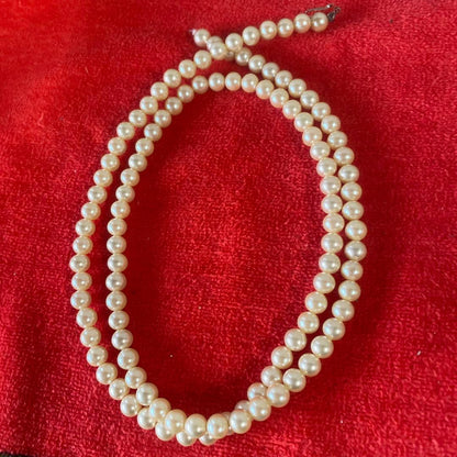 Akoya pearl necklace, matching earrings, and bracelet displayed on a white background