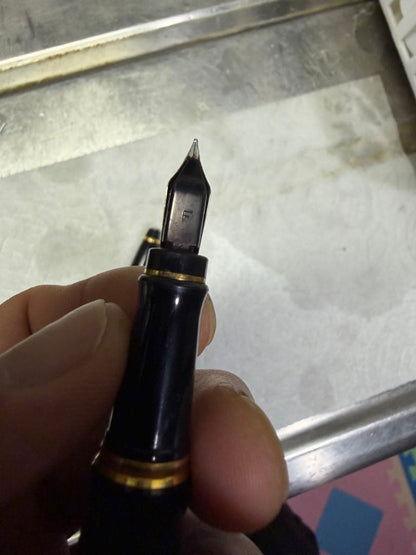 Waterman Paris black gold fountain pen with sleek design and gold accents on a white background