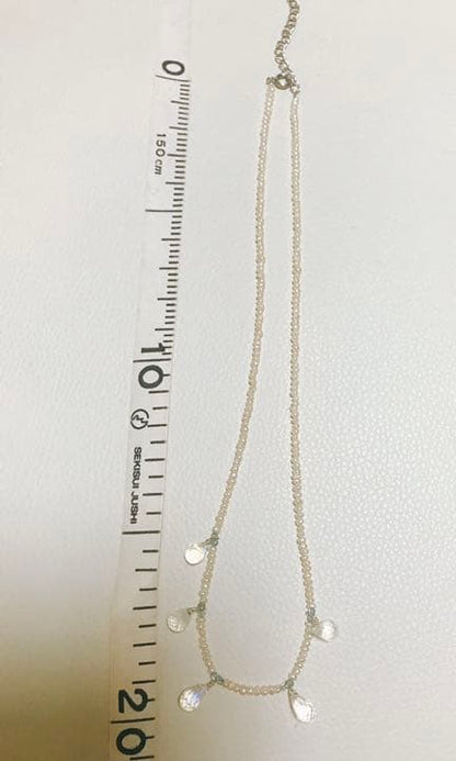 Milky Quartz necklace with aquamarine and freshwater pearl stones on a white background