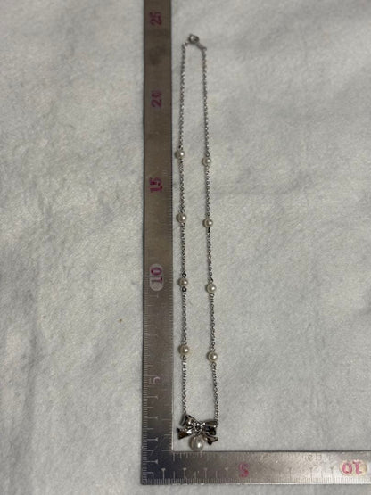 TASAKI elegant silver necklace with lustrous white pearls on a white background