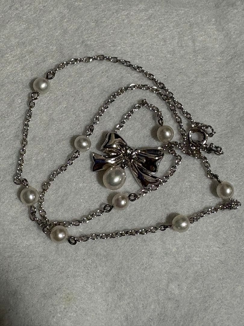 TASAKI elegant silver necklace with lustrous white pearls on a white background