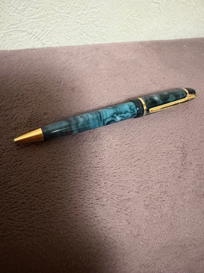 Waterman ballpoint pen in marble blue with gold trim lying horizontally on white background