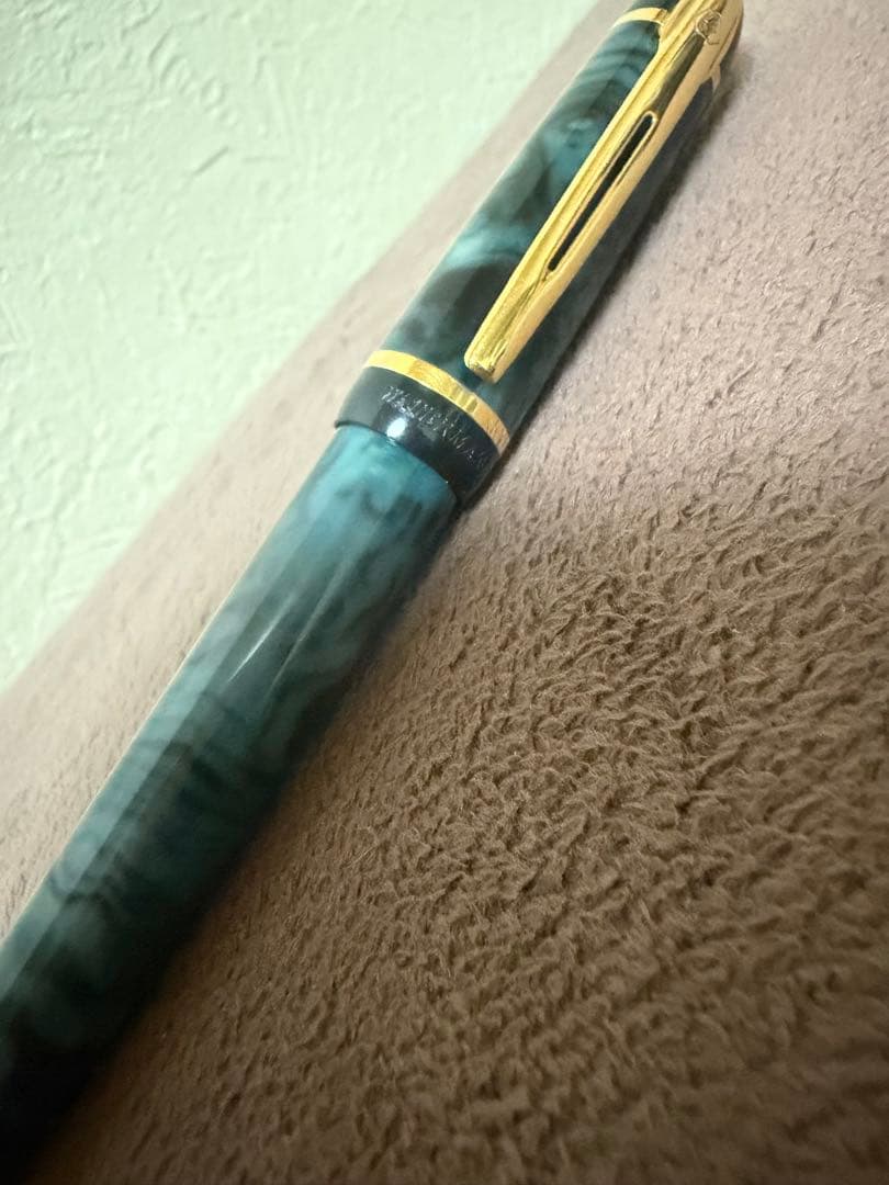 Waterman ballpoint pen in marble blue with gold trim lying horizontally on white background