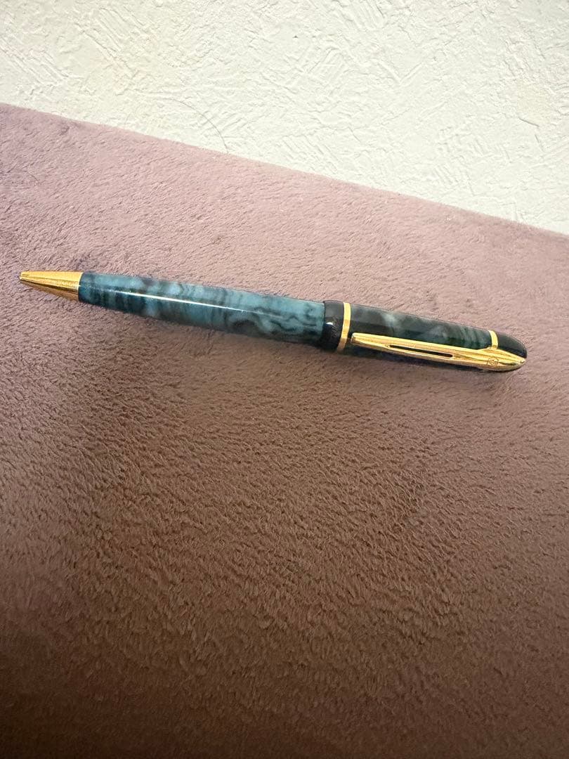 Waterman ballpoint pen in marble blue with gold trim lying horizontally on white background