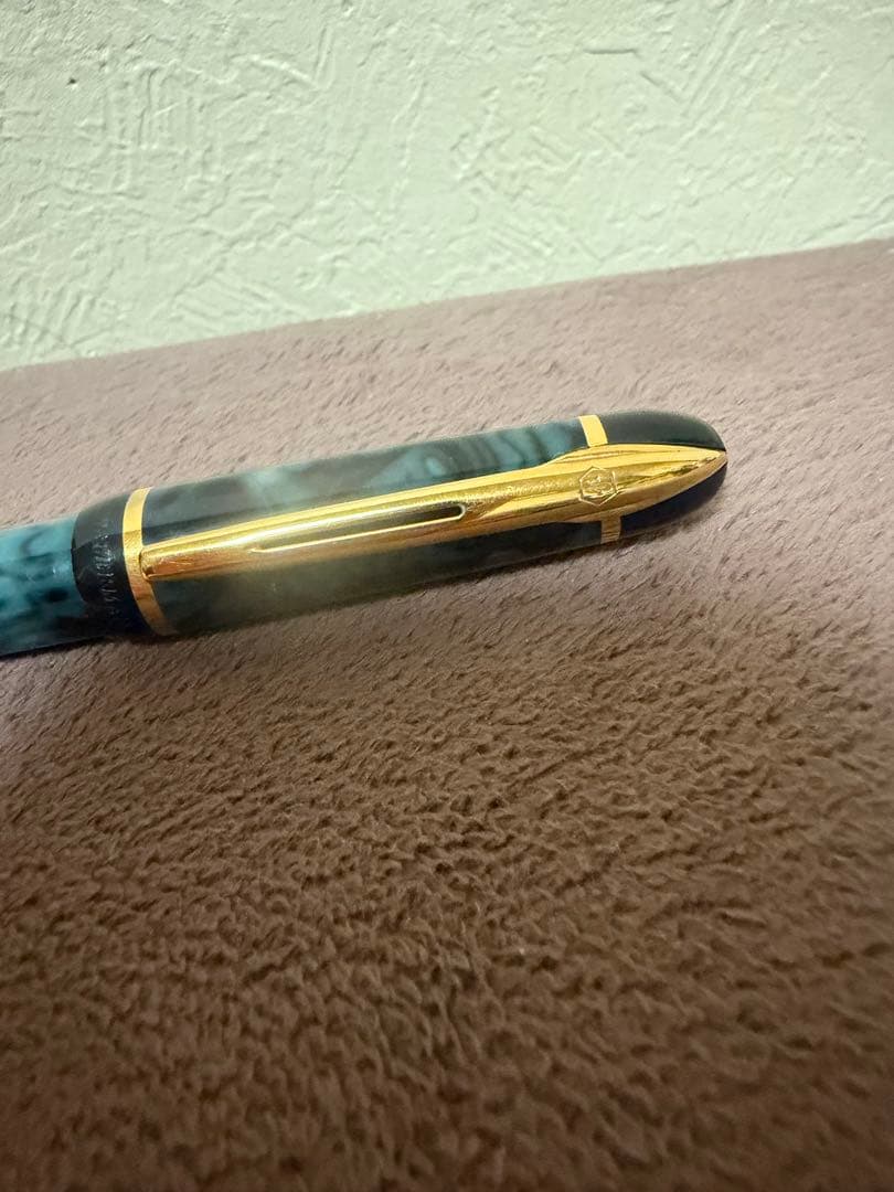 Waterman ballpoint pen in marble blue with gold trim lying horizontally on white background