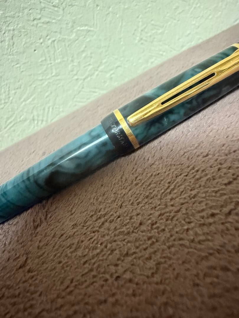Waterman ballpoint pen in marble blue with gold trim lying horizontally on white background