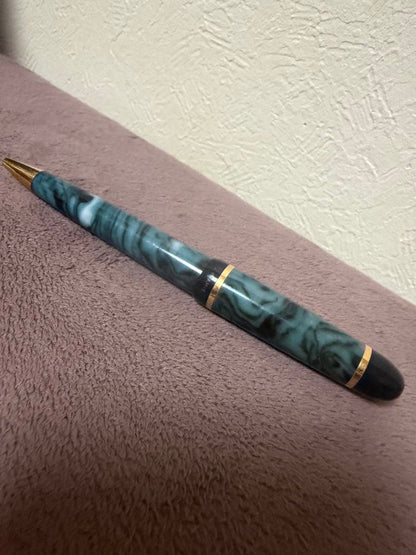 Waterman ballpoint pen in marble blue with gold trim lying horizontally on white background