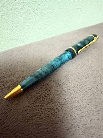 Waterman ballpoint pen in marble blue with gold trim lying horizontally on white background