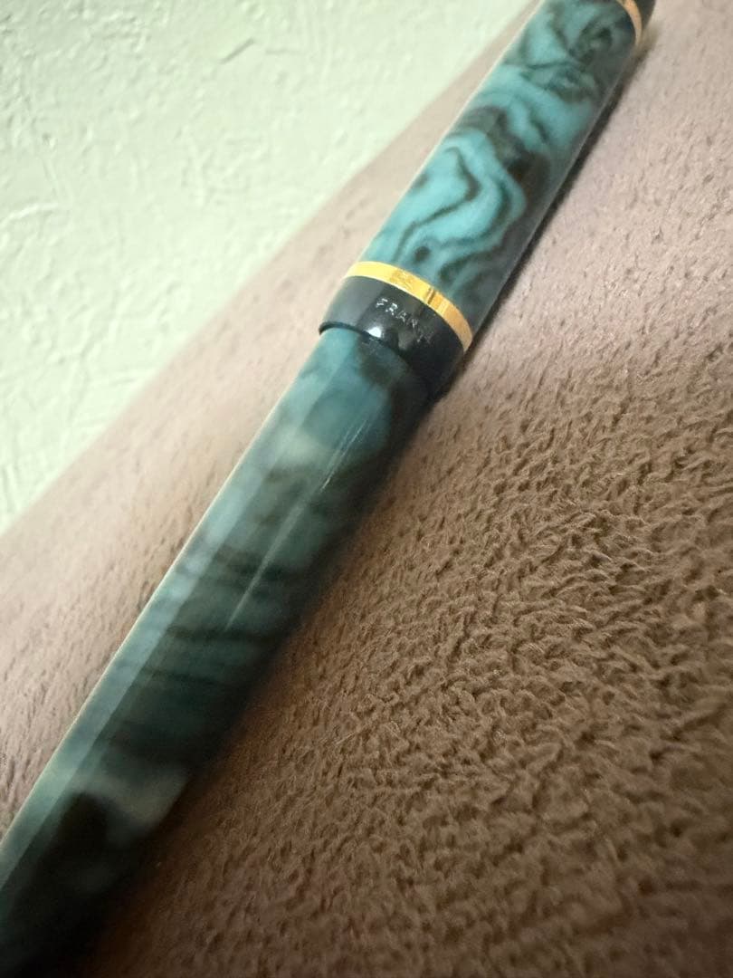 Waterman ballpoint pen in marble blue with gold trim lying horizontally on white background