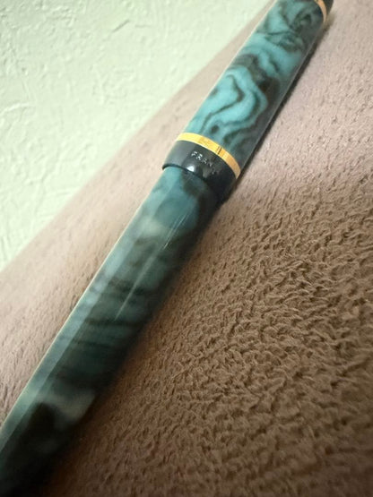 Waterman ballpoint pen in marble blue with gold trim lying horizontally on white background