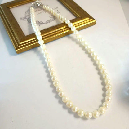 Single-strand Akoya pearl necklace with silver flower motif clasp, creamy white pearls approximately 6.5-6.7 mm diameter