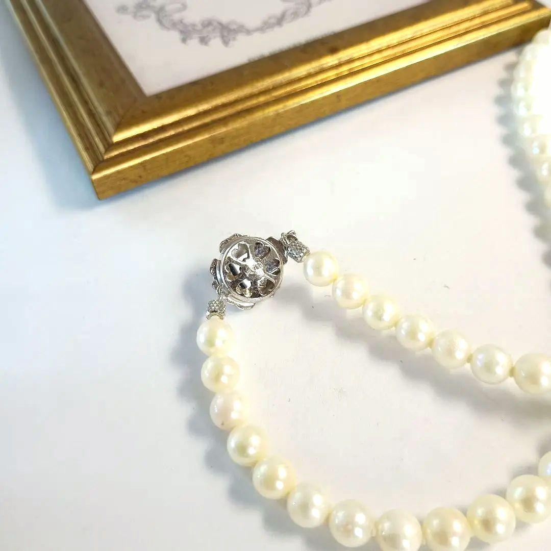 Single-strand Akoya pearl necklace with silver flower motif clasp, creamy white pearls approximately 6.5-6.7 mm diameter