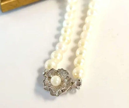 Single-strand Akoya pearl necklace with silver flower motif clasp, creamy white pearls approximately 6.5-6.7 mm diameter
