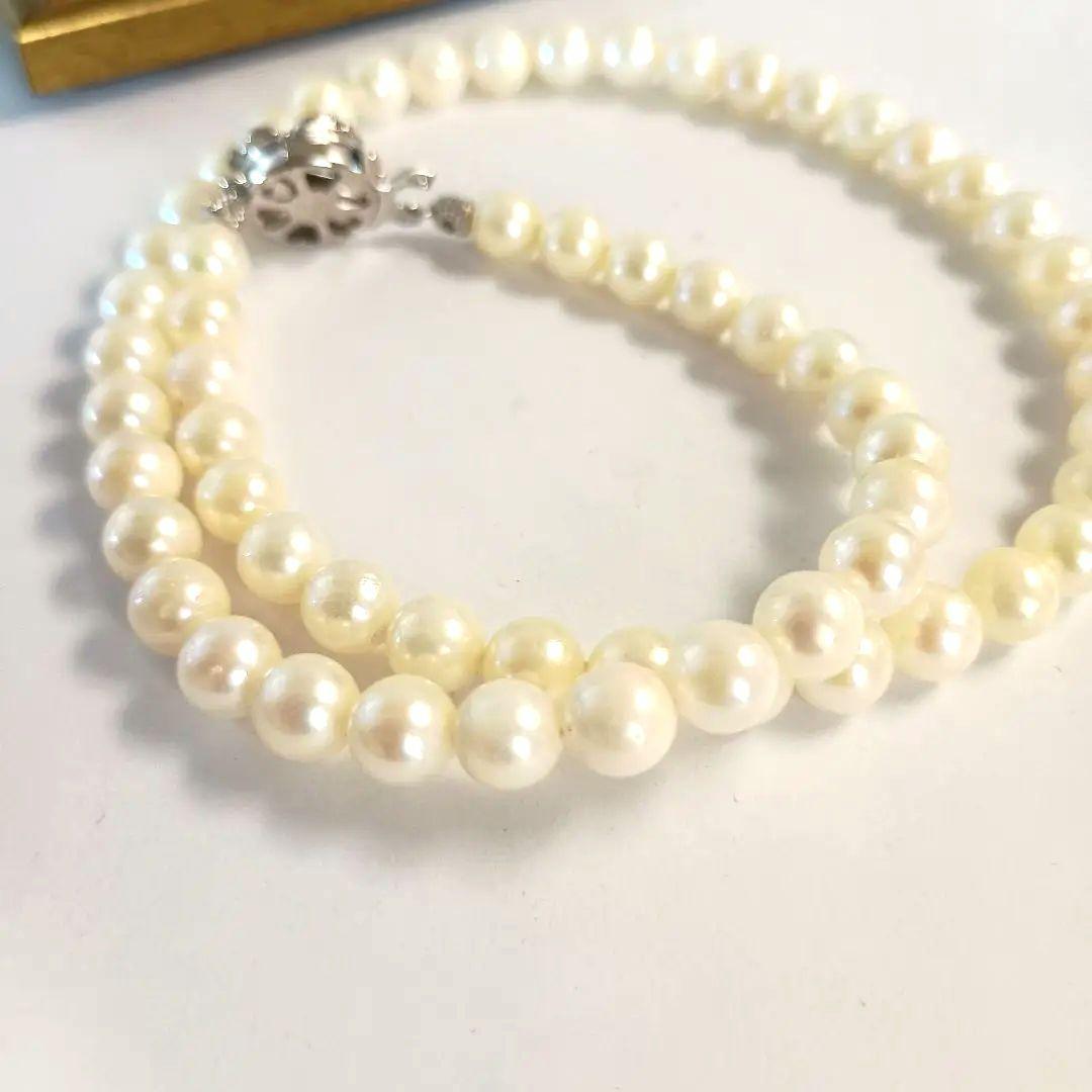 Single-strand Akoya pearl necklace with silver flower motif clasp, creamy white pearls approximately 6.5-6.7 mm diameter