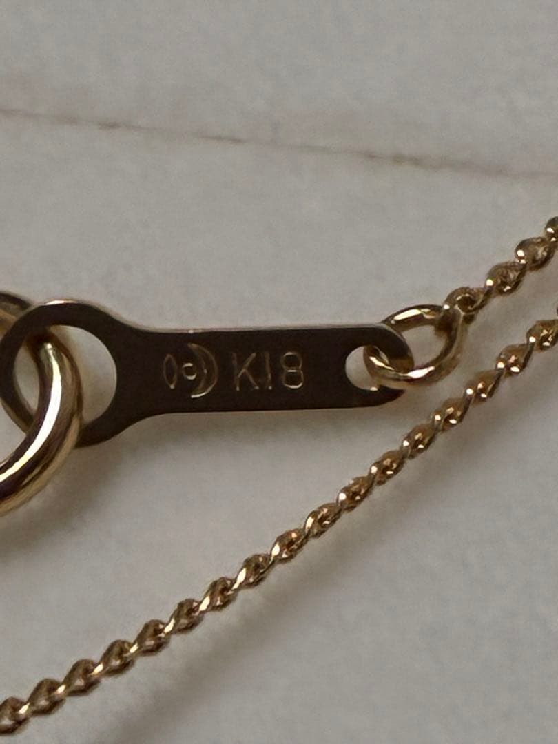 Tasaki K18 Pearl Necklace featuring lustrous pearls and 18 karat gold chain with brand markings