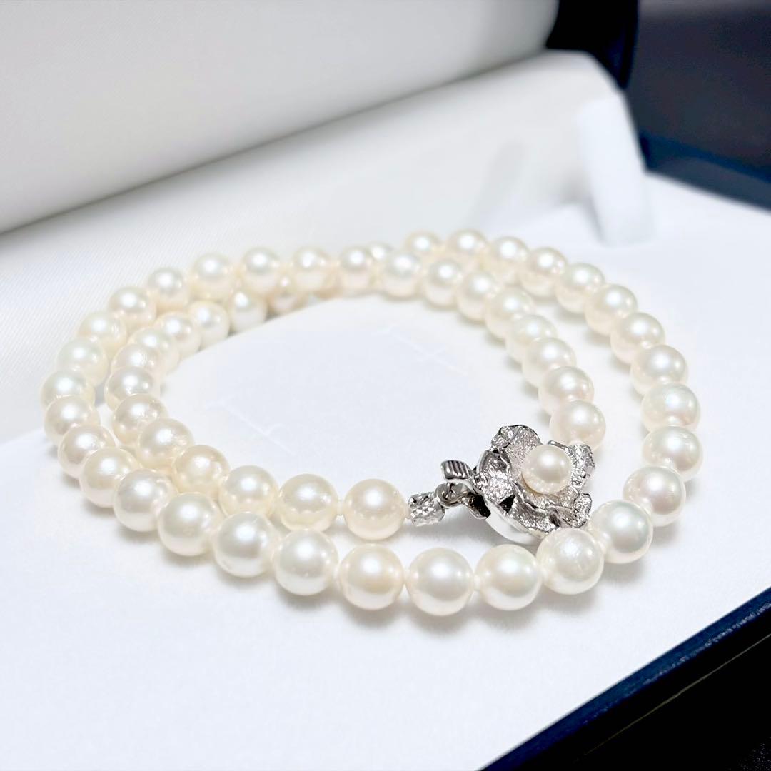 Akoya genuine pearl necklace with 6.4-6.9mm white pearls and silver SV clasp laid out on a white background