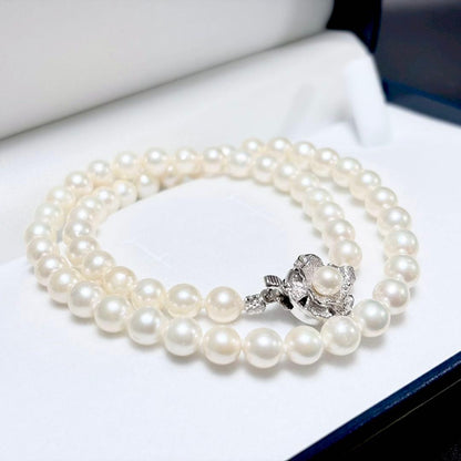 Akoya genuine pearl necklace with 6.4-6.9mm white pearls and silver SV clasp laid out on a white background